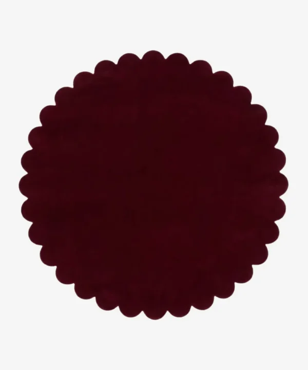 Top down view of the circular Crimson Aura deep red hand tufted wool rug on a white background showing the scalloped border.