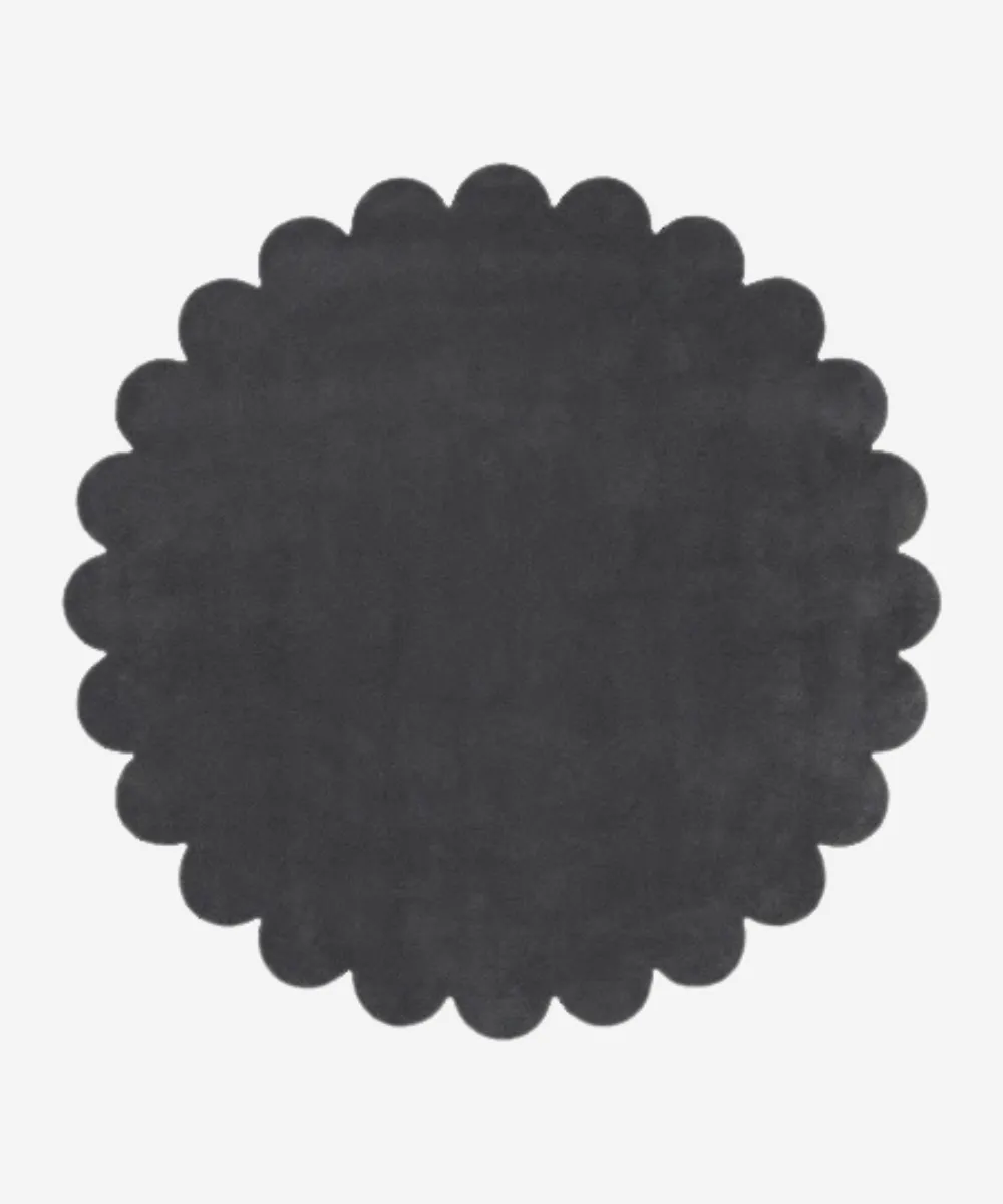 A dark grey round wool rug with scalloped edges, representing the Round Rugs category for browsing circular floor coverings.