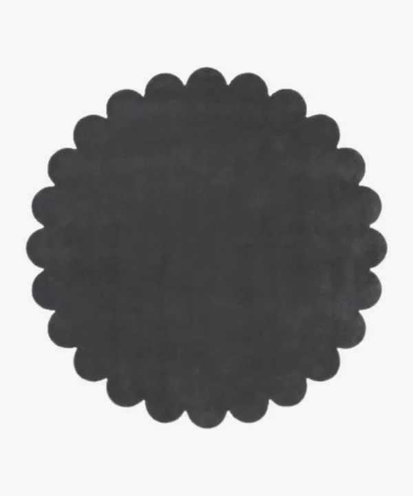 Top down flat lay view of the Slate Cloud round rug showing the dark charcoal grey wool color and scalloped border.