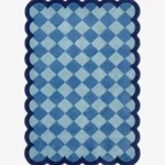Top down view of the Coastal Current rug featuring a diamond checkerboard pattern in soothing shades of light and slate blue, framed by a dark blue scalloped border.