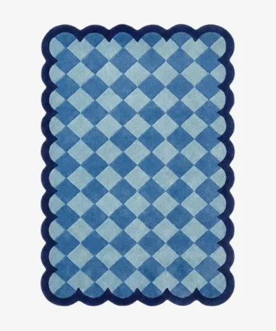 Top down view of the Coastal Current rug featuring a diamond checkerboard pattern in soothing shades of light and slate blue, framed by a dark blue scalloped border.