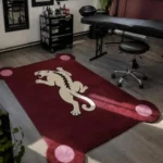 Crimson Prowl handmade tufted area rug featuring a deep red background with a traditional tattoo style white panther illustration and pink corner accents, displayed in a tattoo studio setting.