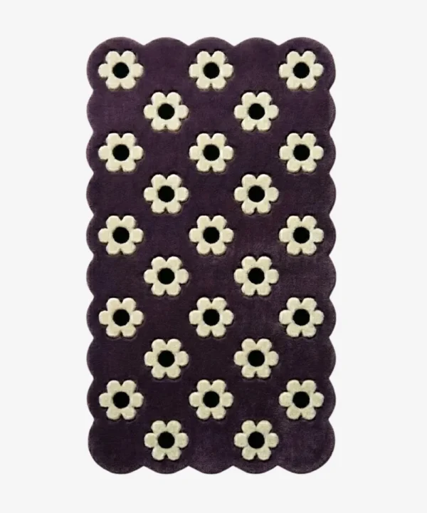 Top down view of the Daisy Night rug featuring a grid of small white daisy flowers on a deep purple wool background with scalloped borders.