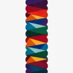 Top down view of the Dash Prism runner rug on a white background, featuring a vibrant geometric design of overlapping colorful triangles in bold red, blue, green, and yellow tones with custom shaped edges.