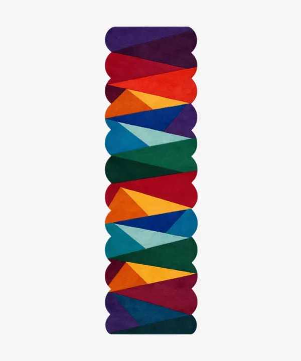 Top down view of the Dash Prism runner rug on a white background, featuring a vibrant geometric design of overlapping colorful triangles in bold red, blue, green, and yellow tones with custom shaped edges.