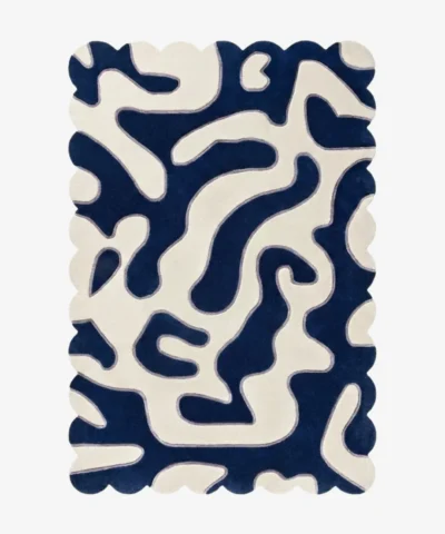 Top-down view of the Inked Dyed rug against a white background, featuring a bold, organic, maze-like abstract pattern in solid deep blue and cream, framed by a continuous scalloped border.