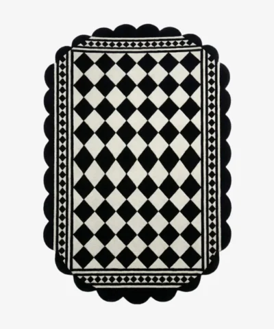 Top down view of the Ivory Lattice rug featuring a classic black and white diamond grid pattern with a geometric border and decorative scalloped edges.