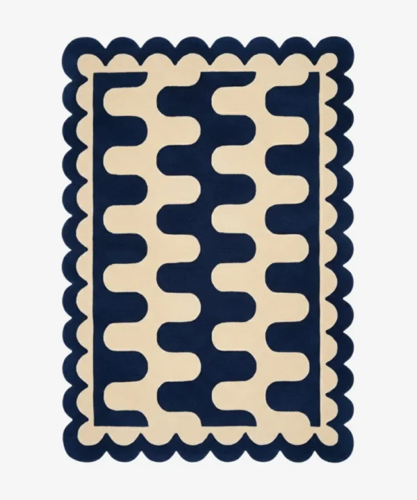 Top down view of the Obsidian Grid rug featuring a deep navy blue wool background with a bold cream wavy geometric pattern and custom scalloped edges.