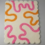 Angled perspective of the Peach Giggle area rug showcasing the modern fun doodle pattern and the decorative wavy scalloped borders.