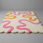 Low angle shot of the Peach Giggle rug highlighting the dense plush wool pile height and the vibrant pop of color perfect for a nursery or kids room.