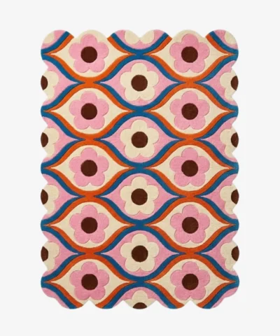 Top down view of the Petal Weave rug featuring a retro repeating floral pattern with pink flowers and blue wavy lines on a cream background.