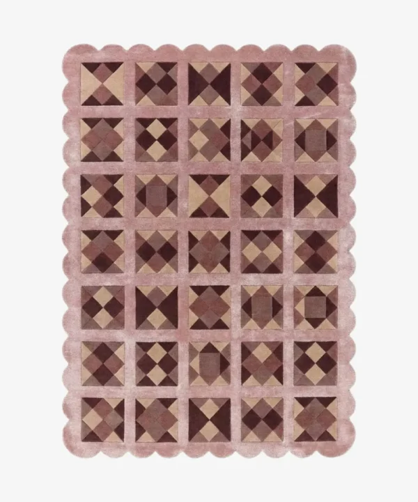 Top down view of the Rose Matrix rug against a white background, featuring a repeating patchwork pattern of geometric squares and diamonds in solid shades of soft pink, mauve, and deep burgundy, framed by a continuous pink scalloped border.