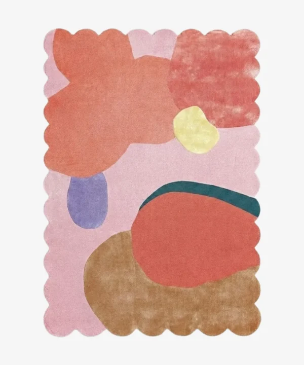 Top-down view of the Rose Riot rug against a white background, featuring large, organic abstract shapes in vibrant shades of coral, peach, yellow, periwinkle, teal, and warm brown on a soft pink background, framed by a continuous pink scalloped border.