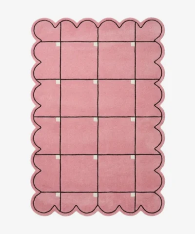 Top down view of the Soft Depth rug featuring a soft pink wool background with a delicate dark grid pattern accented by small white squares and custom scalloped edges.