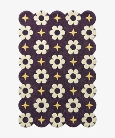 A celestial inspired purple wool rug with scalloped edges, decorated with repeating floral blooms and golden starlight motifs.