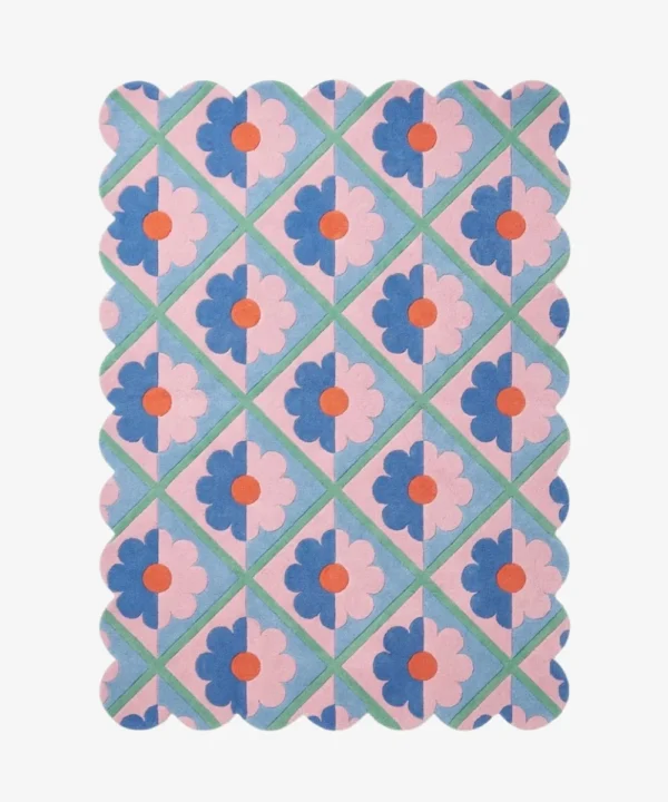 Top down view of the Sugar Trellis rug featuring a retro diamond grid pattern with pink and blue floral motifs and scalloped edges on a hand tufted wool background.