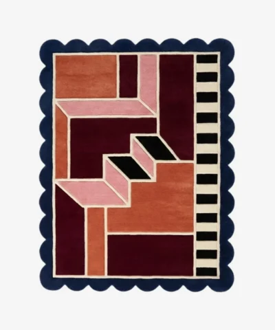 Top down view of the Muted Garnet rug featuring a sophisticated, dusty red wool background with a soft, plush texture and custom scalloped edges.