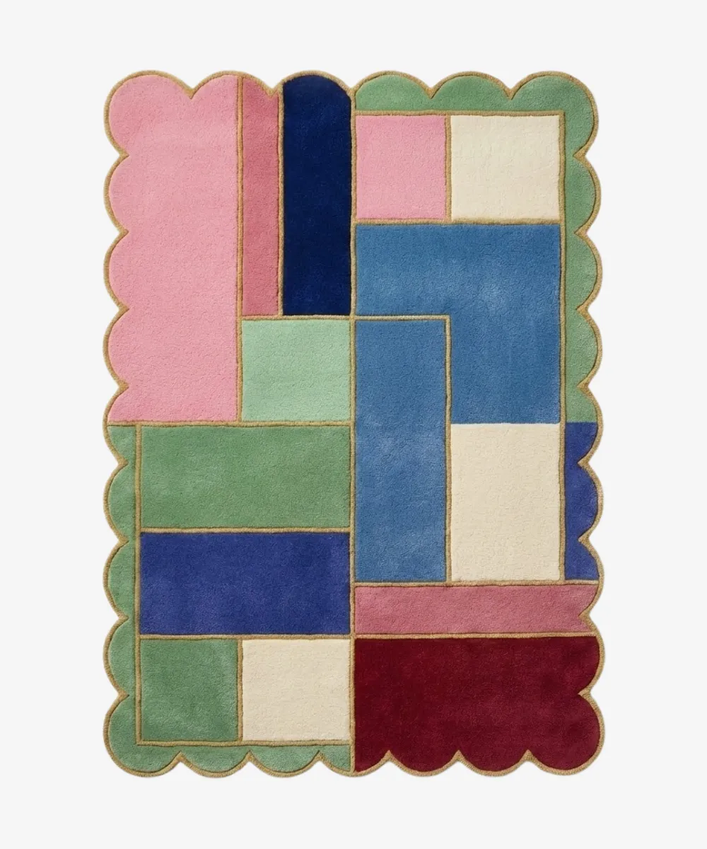 Top down view of the Piatched Poise rug featuring a dynamic, multi-colored geometric block design that mixes pastel shades with deep jewel tones, completely surrounded by a decorative scalloped border.