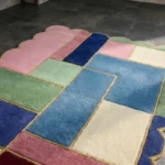 Close-up detail of the Piatched Poise rug, showcasing the plush hand-tufted wool texture, the intricately carved dividing lines between the colorful geometric blocks, and the distinctive scalloped border with its mustard yellow edging.