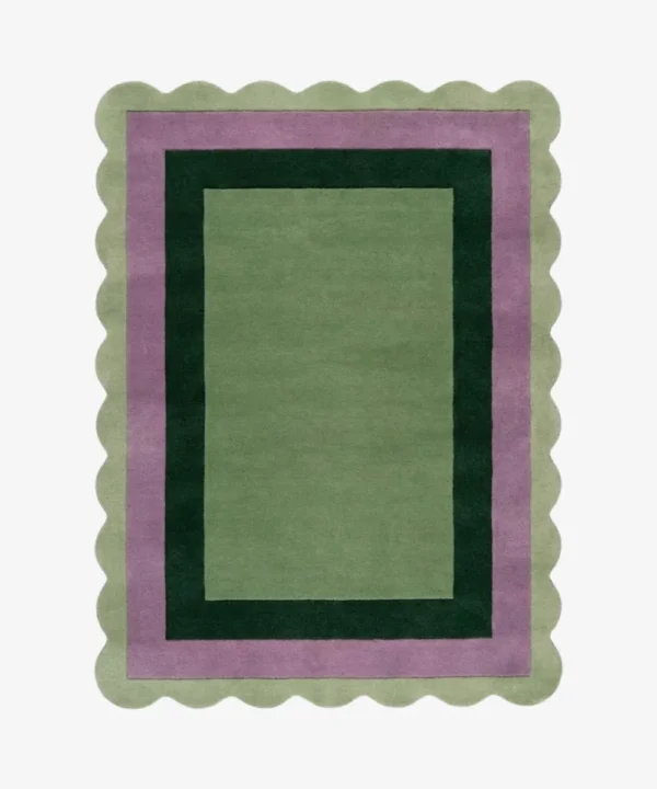 Top-down view of the Trimmed Forest rug against a white background, featuring a classic rectangular design with concentric color-block borders in light green, muted purple, and dark forest green, wrapped around a solid light green center and framed by a continuous light green scalloped edge.