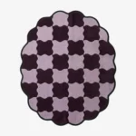 Top-down view of the round Amora Weave rug, featuring a whimsical wavy checkerboard pattern in alternating shades of light lilac and deep plum purple, framed by a continuous black scalloped border.