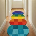 Perspective view of the vibrant Chromatic Stack runner rug styled in a bright, neutral hallway with light hardwood floors, beautifully showcasing its unique stacked-circle silhouette and rainbow color palette.