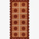 Top-down view of the rectangular Cocoa Ridge runner rug, featuring a retro-inspired grid of light peach squares containing dark cocoa brown circles, all framed by a thick terracotta scalloped border and intersecting cream lines.