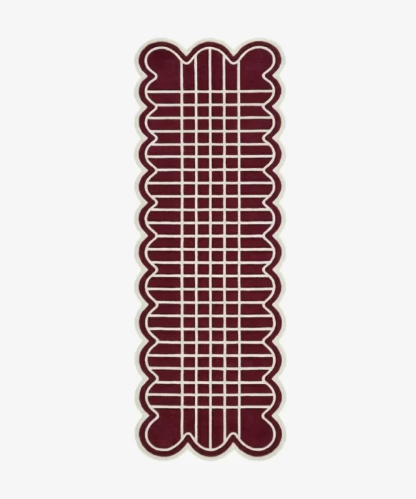 Top down view of the hand-tufted Marvion Trace Runner Rug featuring a deep burgundy background, a cream geometric grid pattern, and scalloped edges.