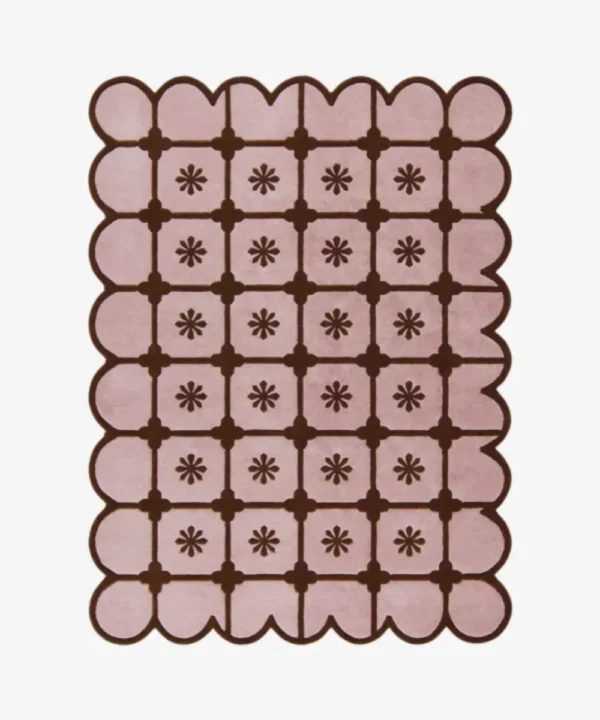 Top-down view of the rectangular Roselle Lattice rug, featuring a soft pink base with a dark brown grid pattern, a central floral motif in each square, and a matching continuous brown scalloped border.