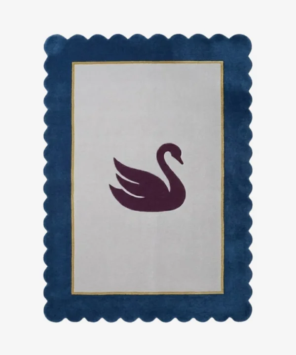 Top-down view of the Swan Crest hand-tufted wool rug featuring a central dark purple swan silhouette on a light grey rectangular field, framed by a thin gold line and a bold navy blue scalloped border.