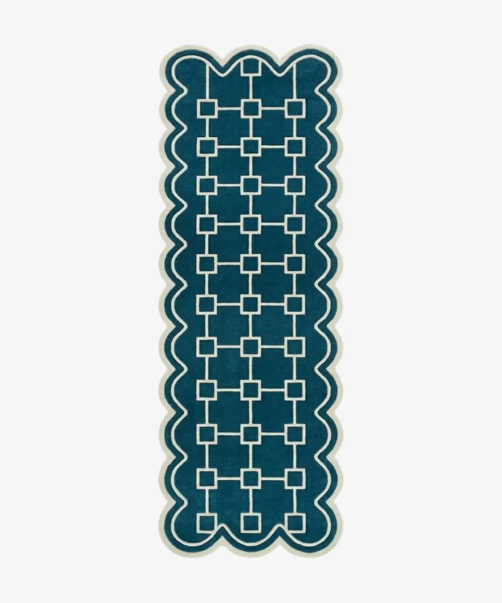 Top down view of the hand-tufted Terenza Coil Runner Rug featuring a rich teal background, a cream geometric square chain pattern, and distinctive scalloped edges.