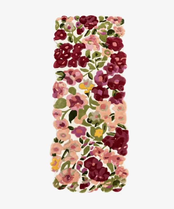 A flat, top-down view of the Cassia Floral Runner Rug isolated on a clean white background. The tufted runner features a vibrant, custom cut-out shape following a dense pattern of pink, burgundy, and purple flowers with green leaves on a cream base.