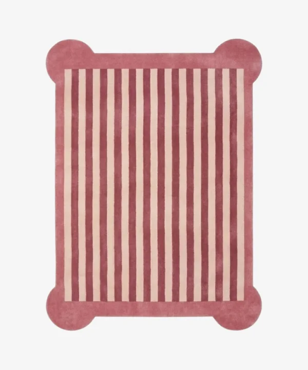 A top-down, flat view of the Rose Candy Stripe Scallop Rug on a clean white background. The tufted rectangular rug features vertical dusty rose and cream stripes, finished with a solid rose-colored border and unique rounded protruding corners.