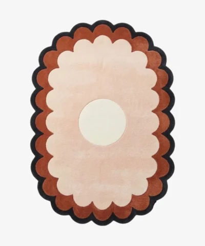 A flat, top-down view of the Sunburst Flower Hand Tufted Wool Rug isolated on a clean white background. The minimalist floral design features a crisp white circular center, surrounded by beautifully tufted, scalloped rings of light pink, terracotta orange, and a dark charcoal grey outer border.