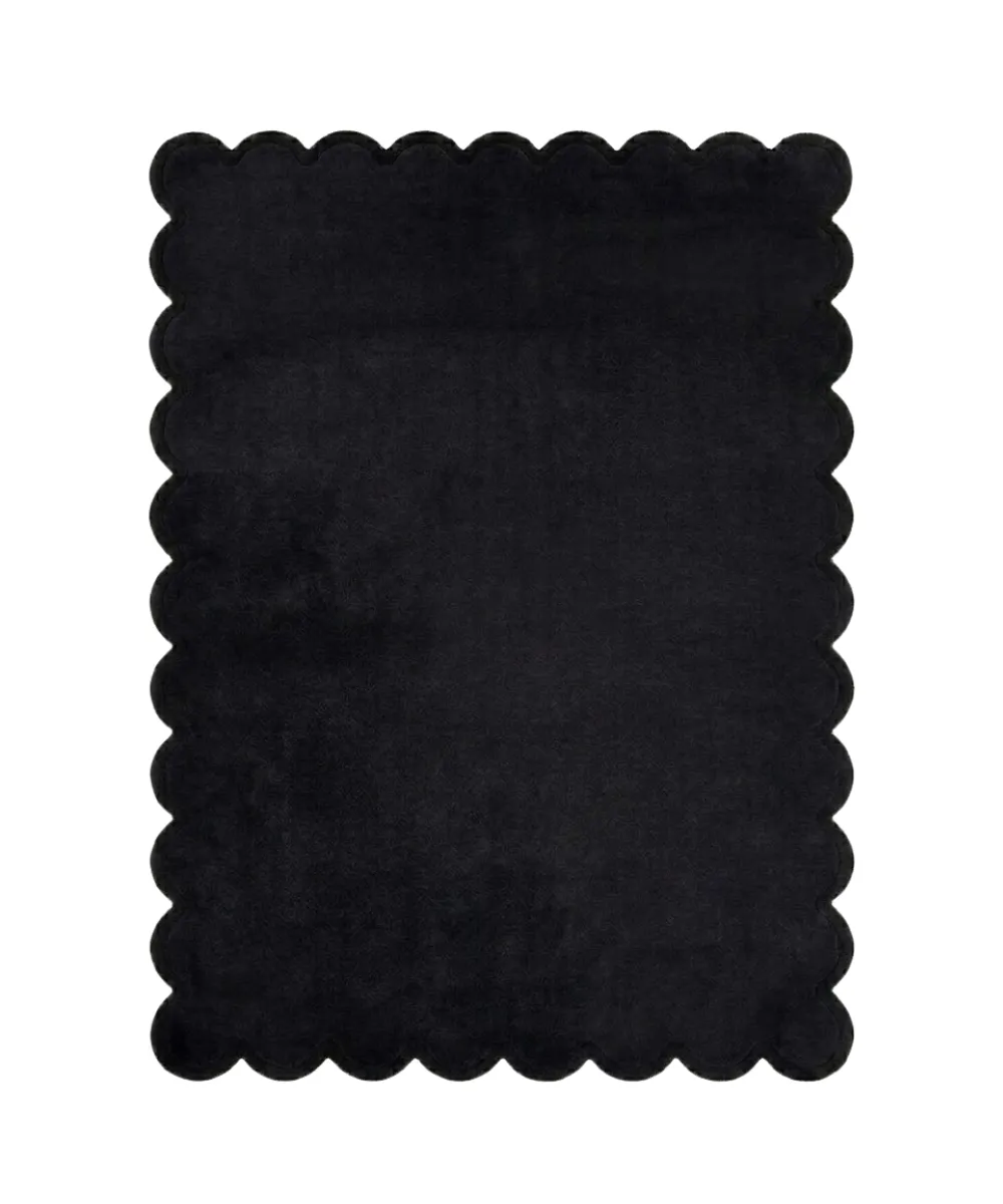 Black hand-tufted scalloped rug showcasing a plush solid color design and curved borders.