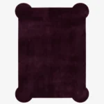 A flat, top-down view of the Bordeaux Scallop Rug isolated on a clean white background. The solid deep burgundy rug features a rectangular silhouette accented by unique, rounded scalloped corners and a rich, plush texture.
