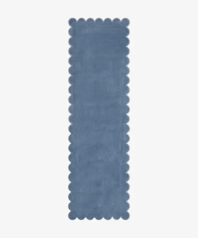 Top-down flat view of a solid dusty blue runner rug showcasing its continuous scalloped edge design against a clean white background.