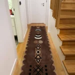 Espresso Nomad runner rug styled in a narrow hallway between a white door and a wooden staircase, highlighting its long, decorative runner shape.