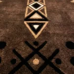 Extreme close-up of the Espresso Nomad runner rug, showcasing the plush brown hand-tufted texture and the detailed black and cream tribal embroidery.