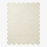 A flat, top-down view of the Evora Ivory Rug isolated on a clean white background. The solid off-white rectangular rug features a continuous, soft scalloped border and a distinct horizontal ribbed texture. Hand-tufted using premium New Zealand wool and viscose, it is crafted with internal stuffing for natural softness and includes a practical anti-slip backing.