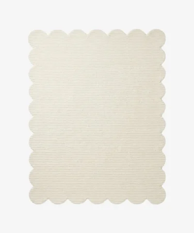 A flat, top-down view of the Evora Ivory Rug isolated on a clean white background. The solid off-white rectangular rug features a continuous, soft scalloped border and a distinct horizontal ribbed texture. Hand-tufted using premium New Zealand wool and viscose, it is crafted with internal stuffing for natural softness and includes a practical anti-slip backing.