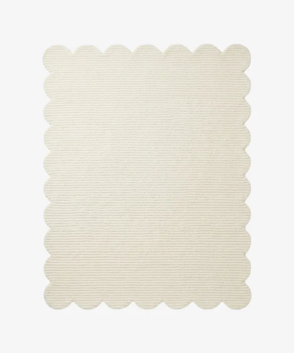 A flat, top-down view of the Evora Ivory Rug isolated on a clean white background. The solid off-white rectangular rug features a continuous, soft scalloped border and a distinct horizontal ribbed texture. Hand-tufted using premium New Zealand wool and viscose, it is crafted with internal stuffing for natural softness and includes a practical anti-slip backing.