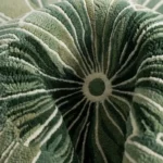 Extreme close-up of the Green Botanical Irregular rug folded, emphasizing the dense, high-quality tufted texture and beautifully carved botanical line details.