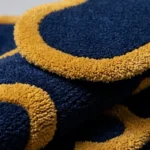 Extreme close-up of the folded Indigo Tide rug, showcasing the premium high-pile wool blend material and precision-cut borders.