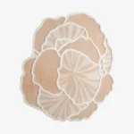 Top-down view of the Lunar Shell rug isolated on a white background, showcasing its abstract, overlapping shell shape in soft off-white tones.
