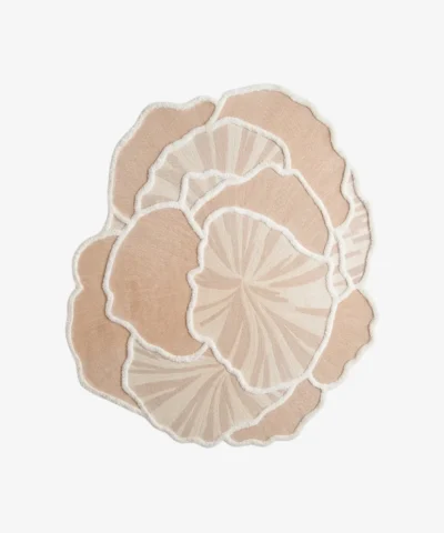 Top-down view of the Lunar Shell rug isolated on a white background, showcasing its abstract, overlapping shell shape in soft off-white tones.