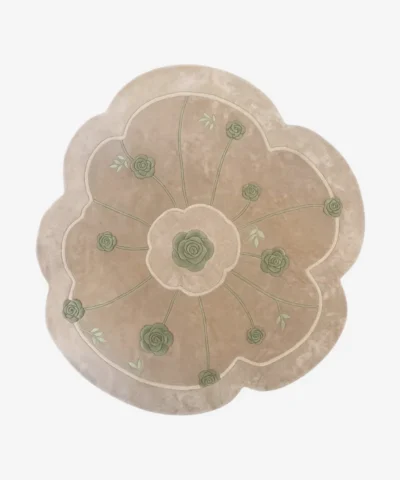 Top-down view of the Meadow Dune rug isolated on a white background, featuring an off-white base with green rose and radiating stem motifs in a scalloped floral shape.