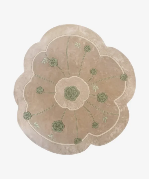 Top-down view of the Meadow Dune rug isolated on a white background, featuring an off-white base with green rose and radiating stem motifs in a scalloped floral shape.