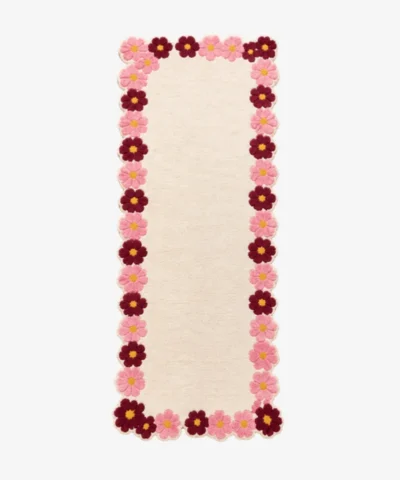 Top-down view of the off-white Petal Frame Runner Rug featuring a decorative border made of pink and burgundy tufted flowers.