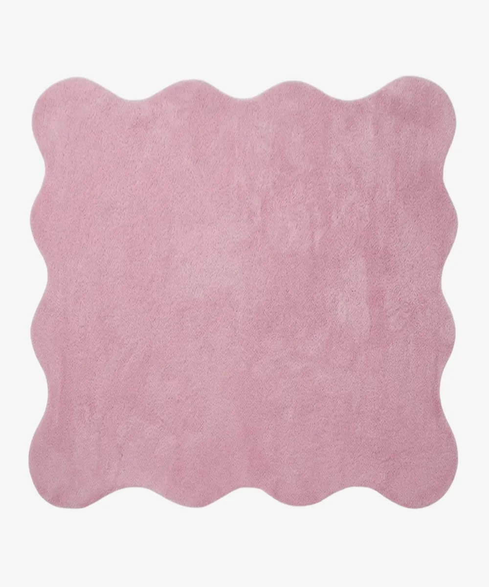 A flat, top-down view of the Roselle Rug isolated on a clean white background. The solid rose pink rug features a playful continuous scalloped border and a decorative carved wavy inner line that elegantly mirrors the outer edge, showcasing its plush hand-tufted texture.